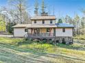 A view of the back of the home highlighting the covered deck and outdoor space at 8445 Vernon Grove Rd, Chattahoochee Hills, GA 30268