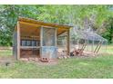 Well-maintained chicken coop with a covered enclosure, providing a safe and comfortable habitat for chickens at 8445 Vernon Grove Rd, Chattahoochee Hills, GA 30268