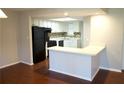 Sunlit kitchen features white cabinets, breakfast bar, wood floors and sleek, black appliances at 2211 Surrey Se Ct, Marietta, GA 30067