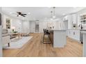 Open concept living area featuring new floors, modern furniture, island seating, and stairway at 3351 Grand Central Dr, Snellville, GA 30078