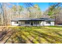 Inviting single-story home with a covered front porch, black shutters and a manicured lawn at 5785 Woodruff Rd, Chattahoochee Hills, GA 30213