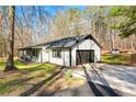 Charming single-story home with an attached garage, driveway, and a well-maintained lawn surrounded by trees at 5785 Woodruff Rd, Chattahoochee Hills, GA 30213