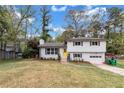 Split-level home with a yellow door, attached garage, and landscaping at 3632 Glen Mora Drive, Decatur, GA 30032