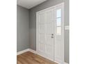 Neutral gray entry with wood look floors and a white front door with sidelight at 386 Northdale Ct, Lawrenceville, GA 30046