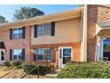 Two story townhouse with brick and beige vinyl siding and dark shutters on a sunny day at 386 Northdale Ct, Lawrenceville, GA 30046
