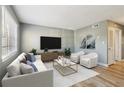 Bright living room featuring modern decor, a plush sofa, and a large flat-screen TV at 386 Northdale Ct, Lawrenceville, GA 30046