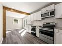 Modern kitchen with white cabinets, granite countertops, stainless steel appliances and a wood beam accent at 2968 Cleburne Pkwy, Powder Springs, GA 30127