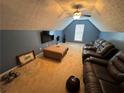Upstairs bonus room featuring plush carpeting, large television, and comfortable seating arrangements at 8827 Lake Rd, Union City, GA 30291