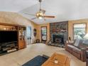 Spacious living room featuring a cozy fireplace, ceiling fan and neutral carpeting at 5 Ridgewood Cir, Mcdonough, GA 30252