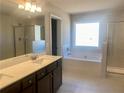 Bright bathroom with double sink vanity, soaking tub, and separate glass enclosed shower at 502 Clayborne Way, Loganville, GA 30052