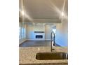 Modern kitchen featuring granite countertops, stainless steel faucet, and view of the fireplace at 502 Clayborne Way, Loganville, GA 30052