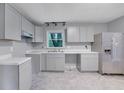 Bright kitchen with gray cabinets, granite countertops, stainless steel appliances, and tile flooring at 1513 Spruce Ridge Way, Stone Mountain, GA 30083