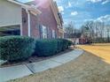 Side exterior view of brick home with a sidewalk and a glimpse of an open garage at 1763 Emerald Dr, Jonesboro, GA 30236