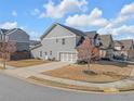 Side view of home showcasing a two-car garage and well-maintained landscaping at 2650 Longacre Park Way, Lawrenceville, GA 30044