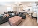 Open-concept living room featuring a comfortable sectional sofa, wood floors, and modern lighting at 3739 Silvery Way, Powder Springs, GA 30127