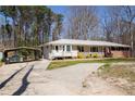 Exterior view of home with carport, featuring a paved driveway and tidy landscaping at 3701 Rainbow Cir, Snellville, GA 30039