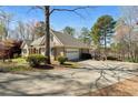 Beautiful home with a spacious driveway and an attached garage nestled among mature trees at 2504 Loch View Sw Ct, Conyers, GA 30094