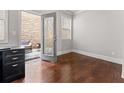 Bright office space featuring hardwood floors, a glass door to the outside and a modern black desk at 736 Red Wolf Run, Atlanta, GA 30349