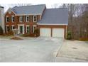 View of a two-story brick home with an attached two-car garage and a large driveway for convenient parking at 179 Hunters Crk, Dallas, GA 30157