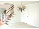Bright foyer with a staircase featuring wood handrails, white risers, and a chandelier at 179 Hunters Crk, Dallas, GA 30157