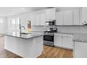 Modern kitchen with stainless steel appliances, granite countertops and hardwood floors at 213 Groveton Ct, Euharlee, GA 30145