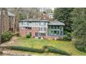 Rear exterior view of home showing brick, siding, large windows, and well-manicured lawn and garden at 2544 Brookdale Nw Dr, Atlanta, GA 30305