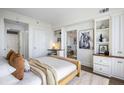 Cozy bedroom with built-in shelving, a work area, and a glimpse into the dining area at 75 14Th Ne St # 3830, Atlanta, GA 30309