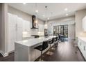 Open kitchen featuring sleek white cabinetry, an expansive quartz island, and modern pendant lighting at 103 Birch St, Decatur, GA 30030