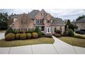 Charming brick home with manicured bushes and a curving driveway leading to the front entrance at 912 Fire Thorn Dr, Hampton, GA 30228