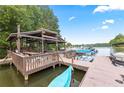 Lakeside covered boat dock featuring a seating area, boat slip, and grilling station at 7115 Harbour Lndg, Alpharetta, GA 30005