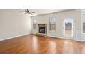 Inviting living room with hardwood floors, a cozy stone fireplace, and ample natural light at 1645 Renfroe Run, Cumming, GA 30041