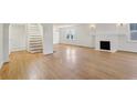 Spacious living room with hardwood floors, a white fireplace, and staircase at 2654 Jefferson Ter, Atlanta, GA 30344
