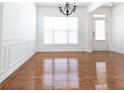 Bright dining room featuring elegant hardwood floors, wainscoting, and a chandelier for ambient lighting at 3277 Wyesham Cir, Duluth, GA 30096