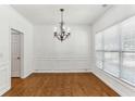 Elegant dining room with hardwood floors, wainscoting, and a modern chandelier at 3277 Wyesham Cir, Duluth, GA 30096