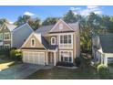 Two-story home with an attached garage, a well-kept lawn, mature trees, and neutral color palette at 3277 Wyesham Cir, Duluth, GA 30096