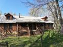 Quaint log cabin with a metal roof and a charming front porch with wooden features at 512 E Valley Ne Rd, Rydal, GA 30171
