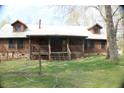 Inviting log cabin with a metal roof and front porch with wooden railing and stairs at 512 E Valley Ne Rd, Rydal, GA 30171