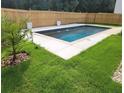 In-ground pool with cool deck, surrounded by new wooden fence and green grass at 939 Brittfield Way, Loganville, GA 30052