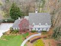 An aerial view of the home showcases its well-manicured lawn, walkway, and tree-lined lot in a quiet neighborhood at 2385 Hanover West Ln, Atlanta, GA 30327