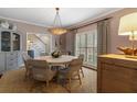 Elegant dining room featuring a round table with seating for six, complemented by a stylish light fixture at 2385 Hanover West Ln, Atlanta, GA 30327