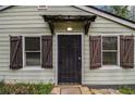 Close-up of the front door with a security screen, shuttered windows, and simple covered porch at 3020 Harold Se Ave, Atlanta, GA 30316