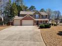 Inviting two-story home with a three-car garage, well-manicured front yard, and a charming front porch with seasonal wreath at 2702 Brookefield Nw Ln, Kennesaw, GA 30152