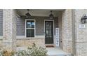 Inviting front porch with brick columns, stylish lighting, and a welcoming 'welcome' sign at 1116 Heatherland Dr, Marietta, GA 30066
