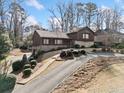 A winding driveway leads to this charming two-story house with stone accents and mature landscaping at 1905 Castleway Ne Ln, Atlanta, GA 30345