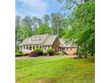 Beautiful brick home with lush landscaping and a well manicured lawn on a sunny day at 3550 Gravitt Rd, Cumming, GA 30040
