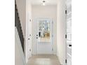 Bright entryway featuring a glass-paneled door, light hardwood floors, and a staircase to the upper level at 712 Shetland Trl, Cartersville, GA 30121