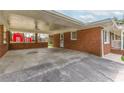 Spacious brick carport offering ample covered parking with a view of the quaint red barn at 2852 Crabapple Lane, Dacula, GA 30019