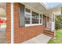 Close-up of home's brick facade, showcasing the shuttered windows and neat, tidy front porch at 2852 Crabapple Lane, Dacula, GA 30019