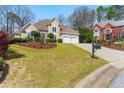Charming home featuring manicured lawn, inviting archway, and a convenient two-car garage at 4441 Langdon Se Walk, Smyrna, GA 30080