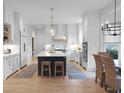 Bright, modern kitchen with white cabinets, stainless steel appliances, a center island, and a cozy dining area at 1025 Abingdon Ln, Johns Creek, GA 30022